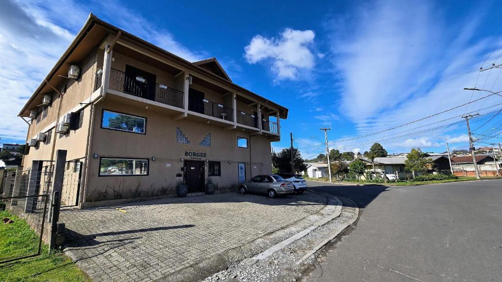 a building with a car parked in front of it at Residencial Borges Canela in Canela