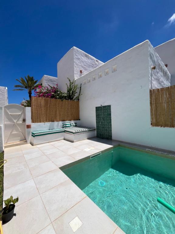 a swimming pool in the backyard of a house at Dar Lisa - Charming authentic beachfront villa in Aghīr