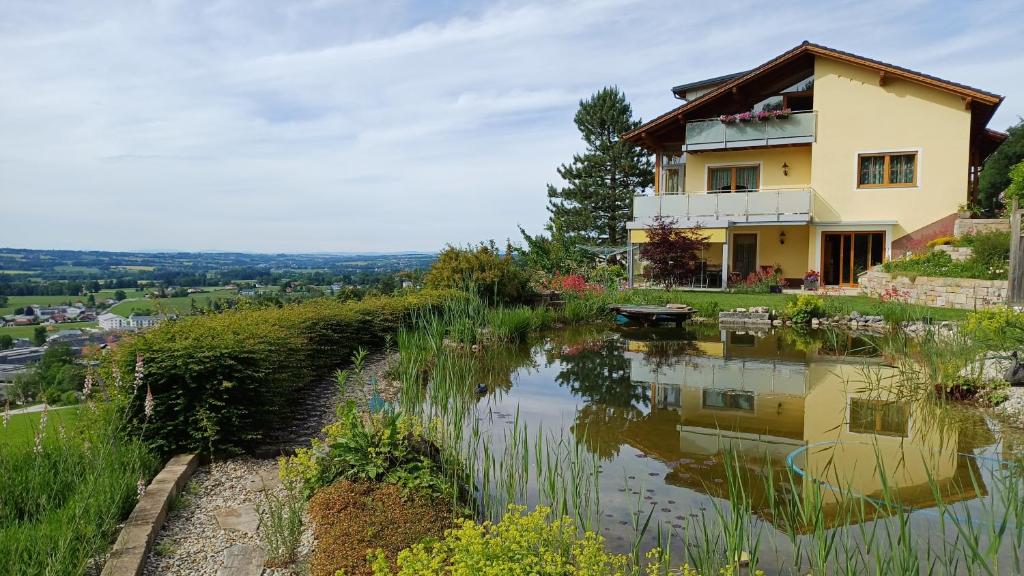 a house on top of a hill with a pond at Haus Margit in Schlierbach