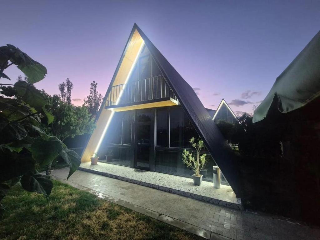 a large building with a light on the side of it at Eco Villa, A frame with barbecue zone and pool in Yerevan