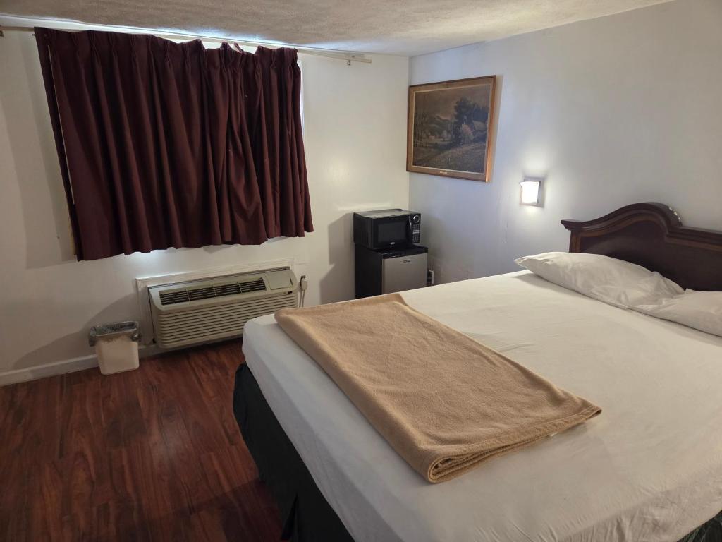 a hotel room with a bed and a window at Huntingdon Inn in Irwin