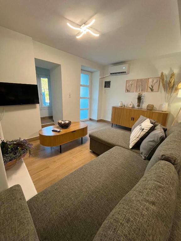 a living room with two couches and a tv at Aegean View House Plomari in Plomari