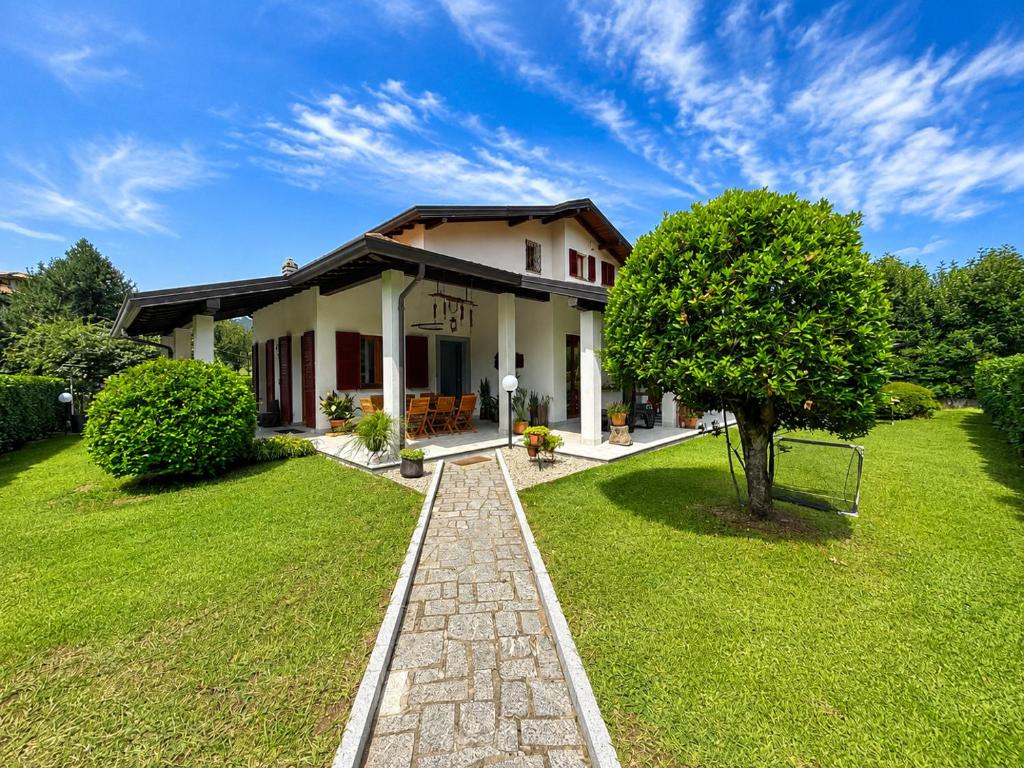 a house with a green lawn and a tree at Villa dei Mumi in Luino