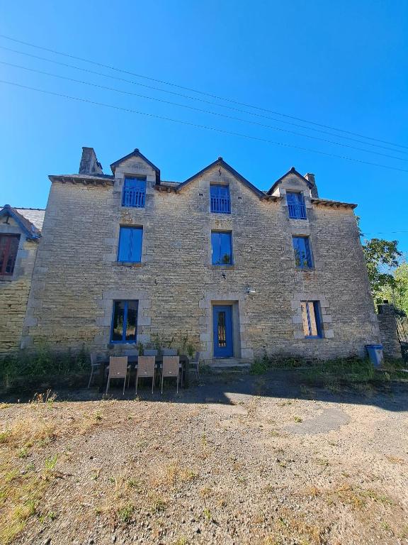 a large brick building with chairs in front of it at La Ferme de Tréfumel in Tréfumel