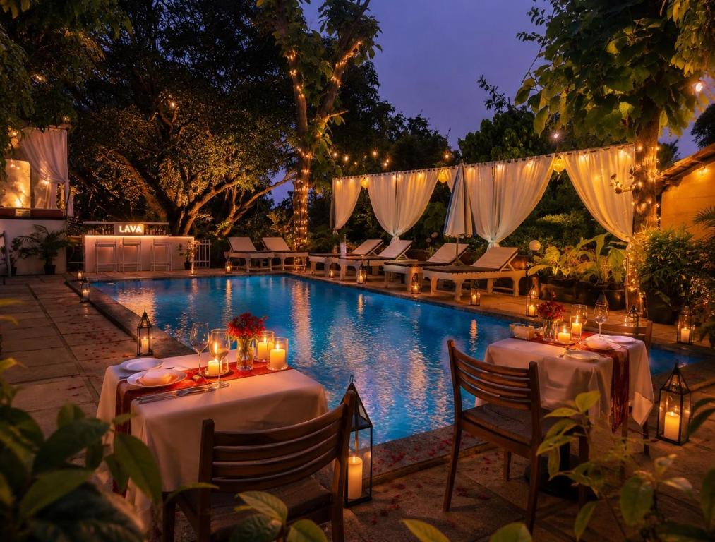 a swimming pool with two tables and chairs and lights at Aaria Hills in Arambol