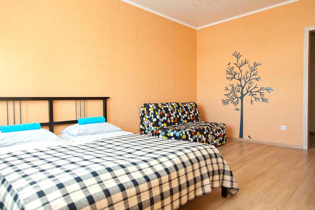 チュメニにあるHappy Apartments on Semenova 31のベッドルーム1室(ベッド1台、椅子付)
