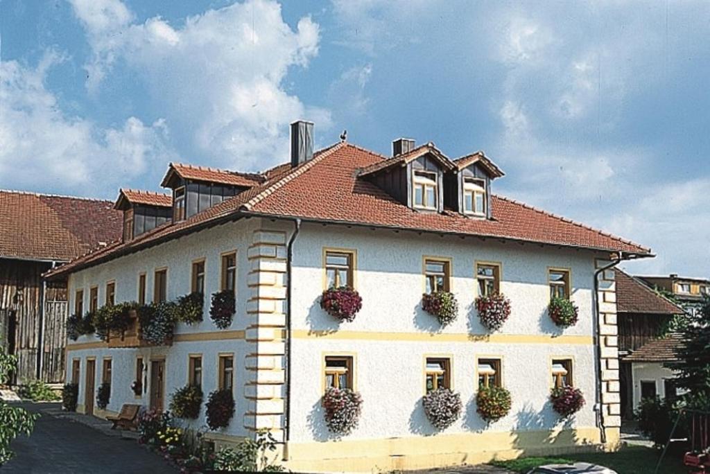 ein großes weißes Gebäude mit Topfpflanzen darauf in der Unterkunft Mirtl-Hoarl-Hof in Eschlkam
