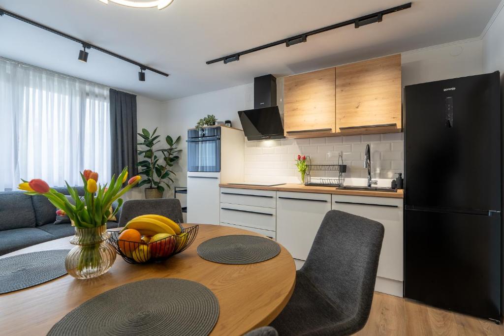 a kitchen with a table and a black refrigerator at The Nest Otočac in Otočac