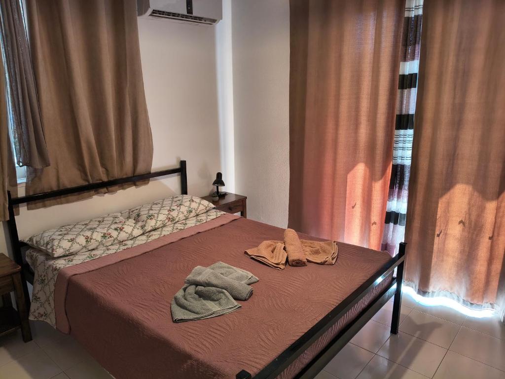 a bedroom with a bed with two towels on it at Hibiscus Green Apartments in Afantou