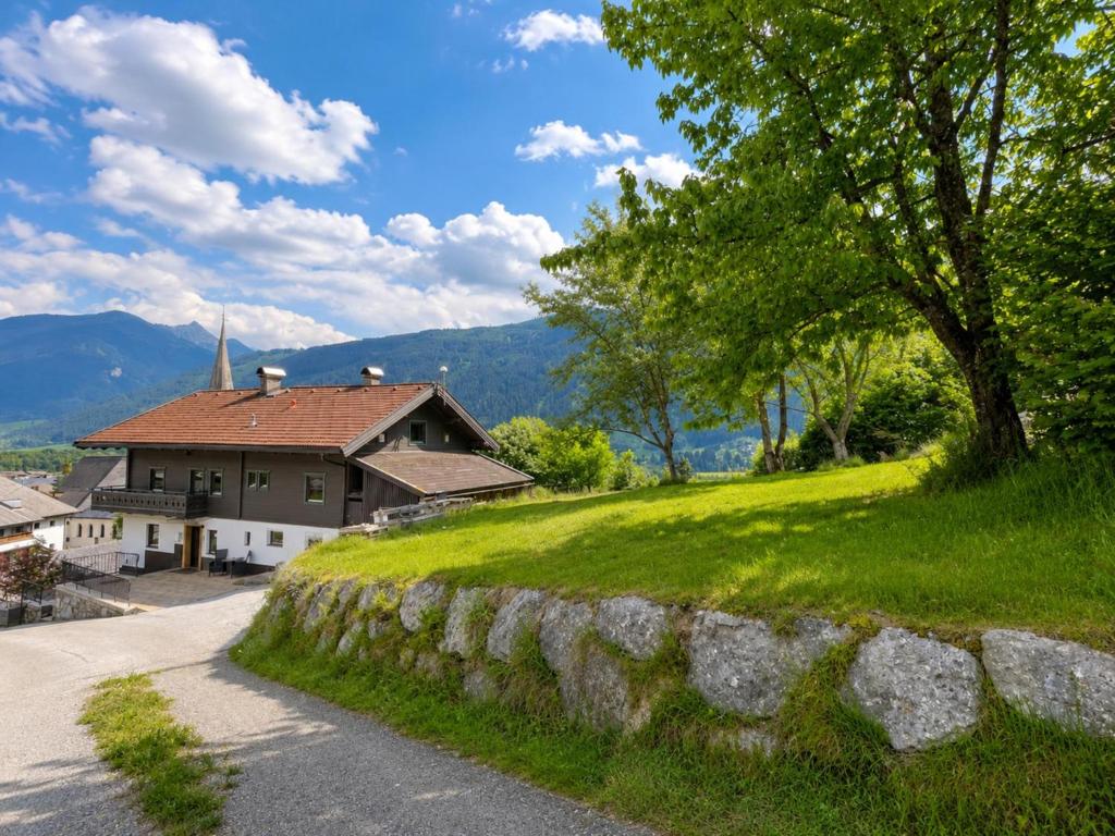 a house on a hill next to a stone wall at Haus am Stein in Stuhlfelden