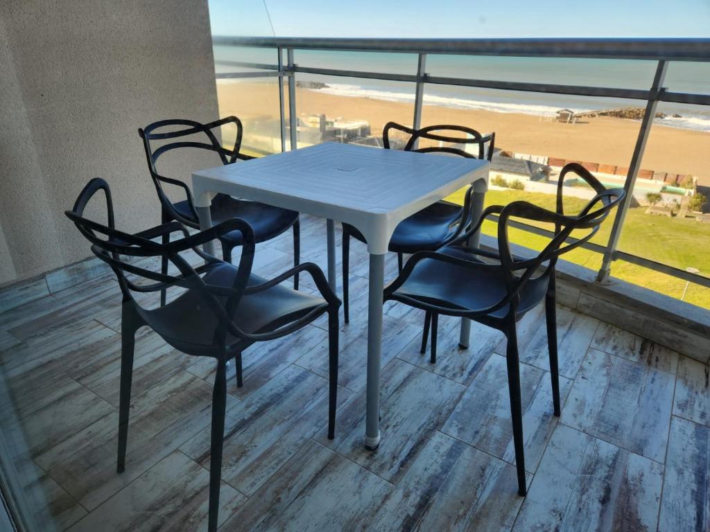 a table and chairs on a balcony with the beach at Frente al Mar con cochera in Miramar