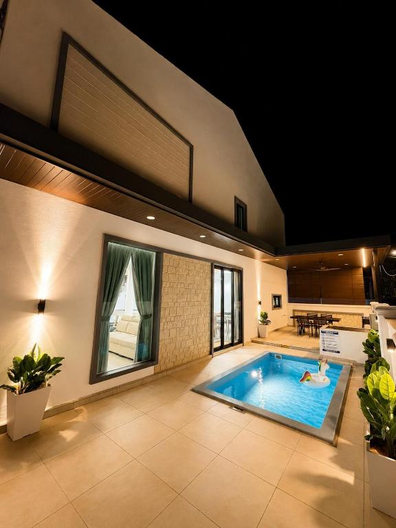 a large indoor pool with a person swimming in it at Chin Villa in Simpang Ampat