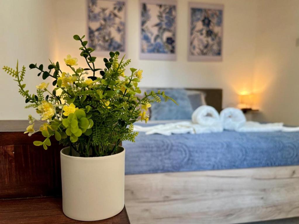 a white vase with flowers on a table in a bedroom at 166, Rodolfu in Sliema