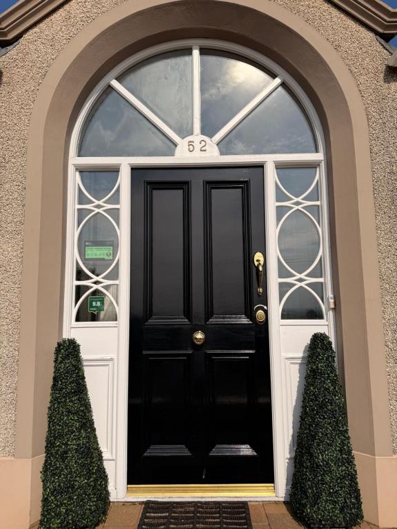 a black front door of a house at Causeway Lodge in Bushmills