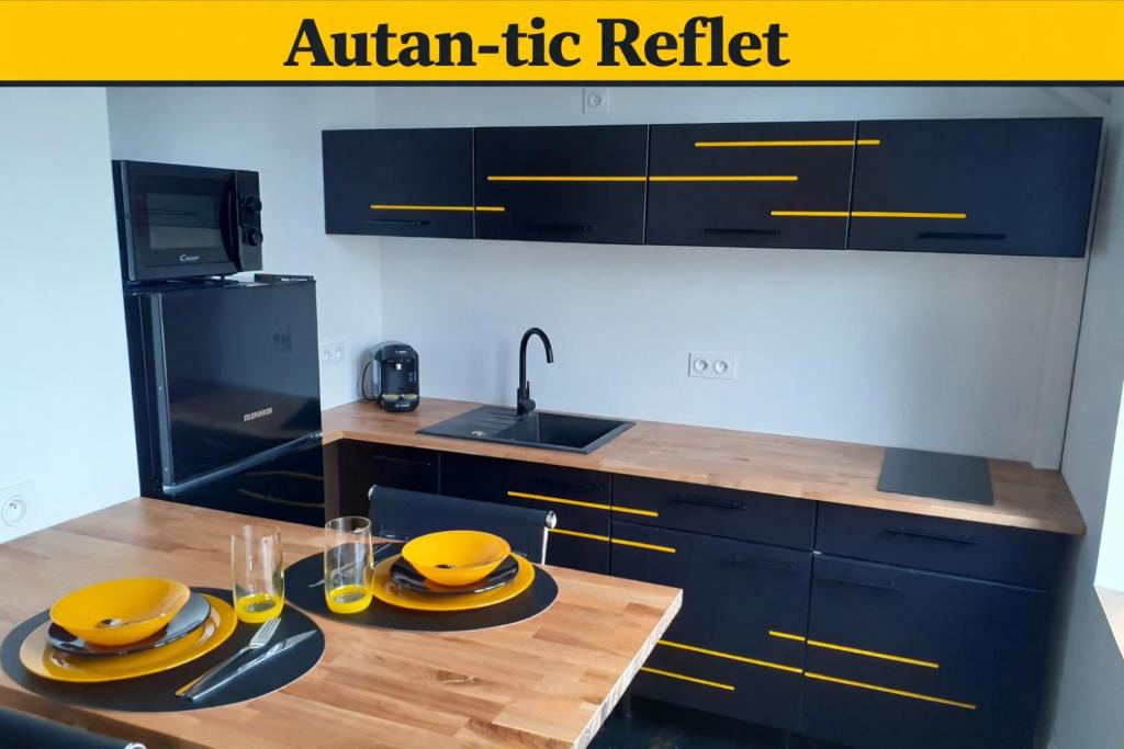 a kitchen with a wooden table with yellow dishes on it at Autan-tic in Castres