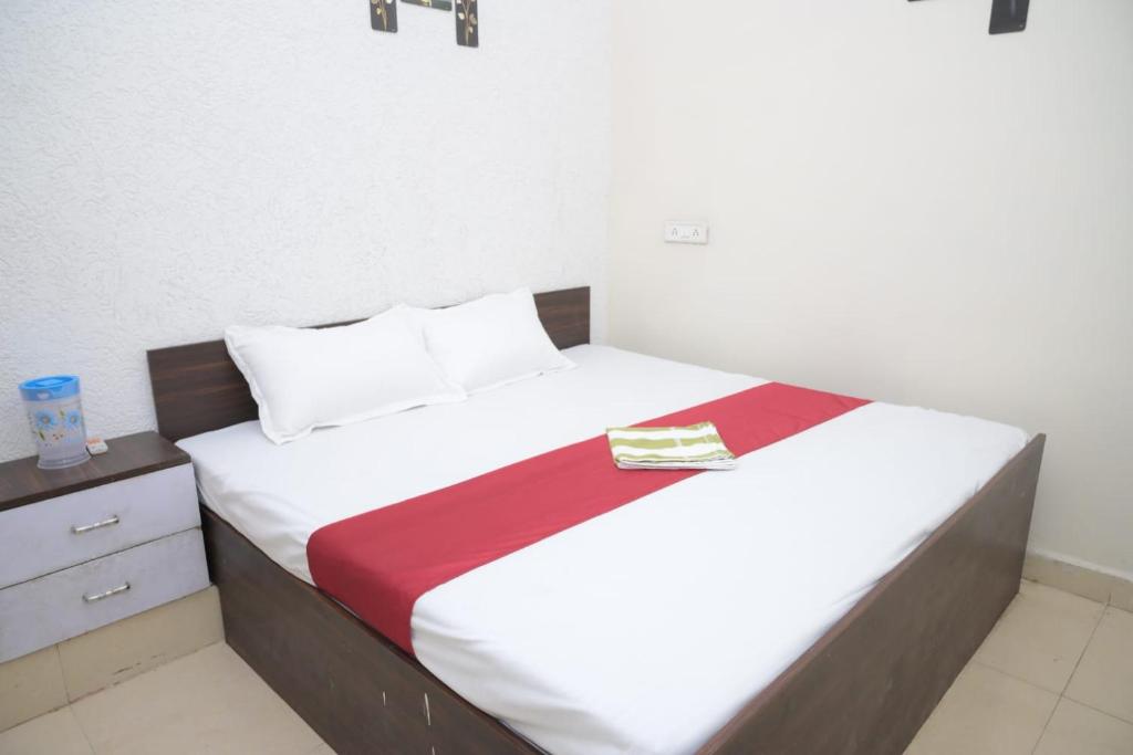 a bed with white sheets and a red blanket at Hotel dream sagar in Sāgar