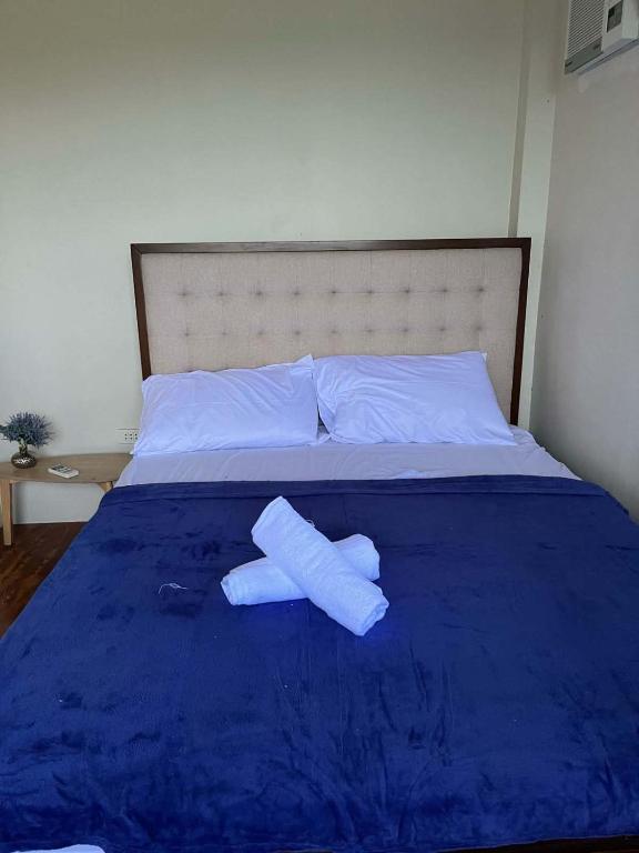a bed with two rolled up towels on it at Casa de Lilong in Mahinog