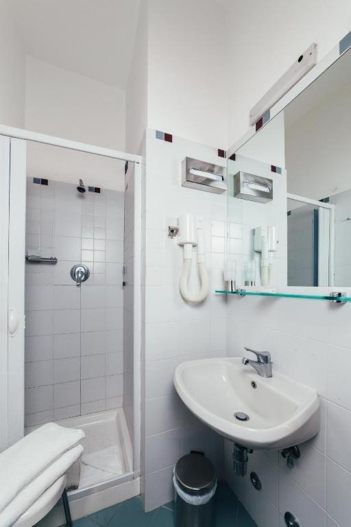 a white bathroom with a sink and a shower at Arcangelo Meublè in Rimini