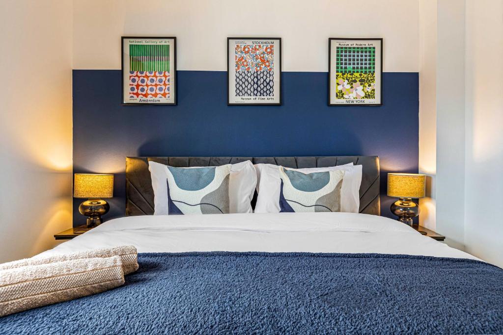 a bedroom with a bed with four pictures on the wall at Contractor Base Parking 4 Beds Fast Wi-Fi in Bolton upon Dearne