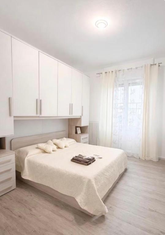 a white bedroom with a large bed with white cabinets at Liam House - Stanza 1 in Limbiate