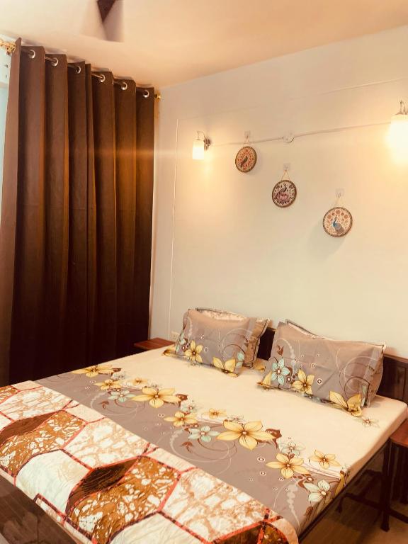 a bedroom with a bed with flowers on it at Ra3sheesh Abode Comfort Connectivity and Charm in Dera Bassi
