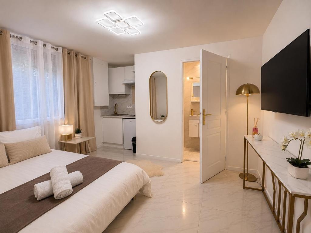 a bedroom with a large bed and a kitchen at Studio Chic - Centre-Ville in Sablé-sur-Sarthe