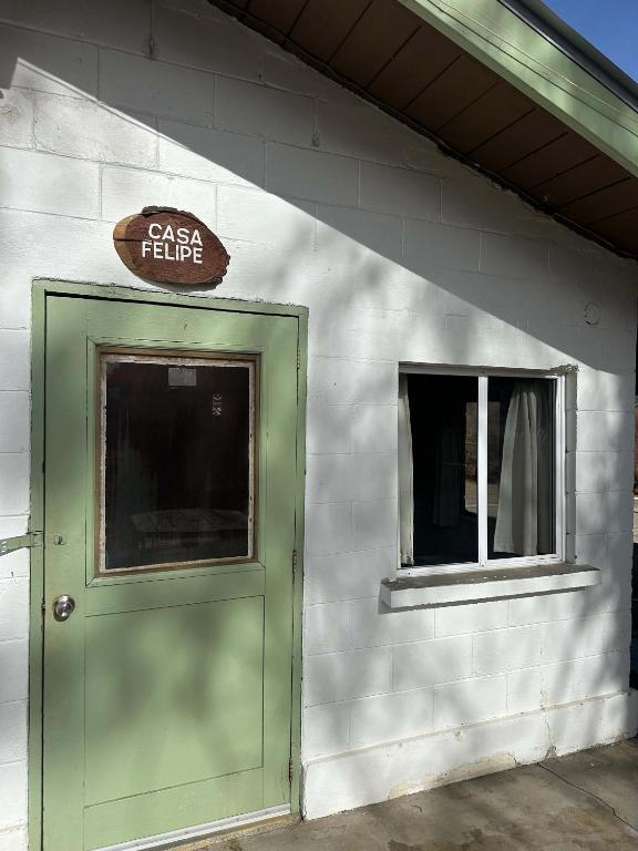 a building with a green door and a sign above it at Rancho Meling Casa Felipe in Camalú