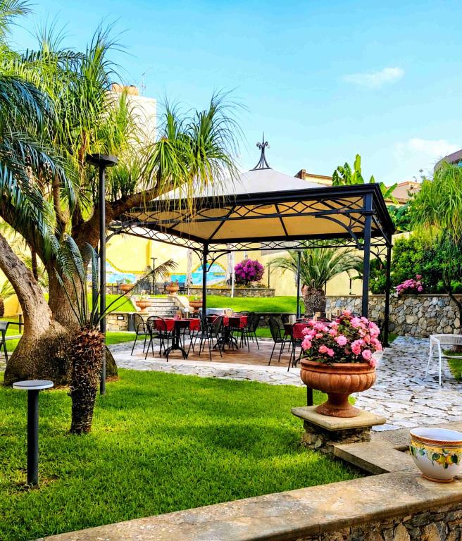 a garden with a pavilion with a table and chairs at Hotel Garibaldi in Milazzo