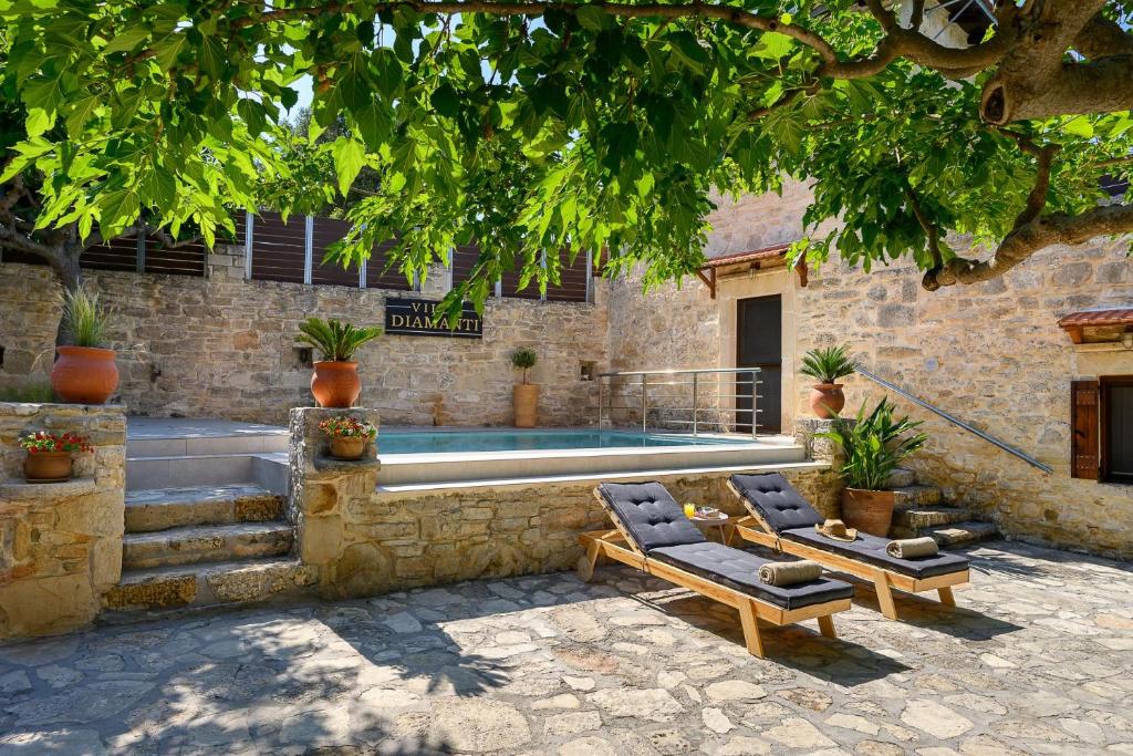 a patio with two lounge chairs and a swimming pool at Villa Diamant 1860 in Monókhoron