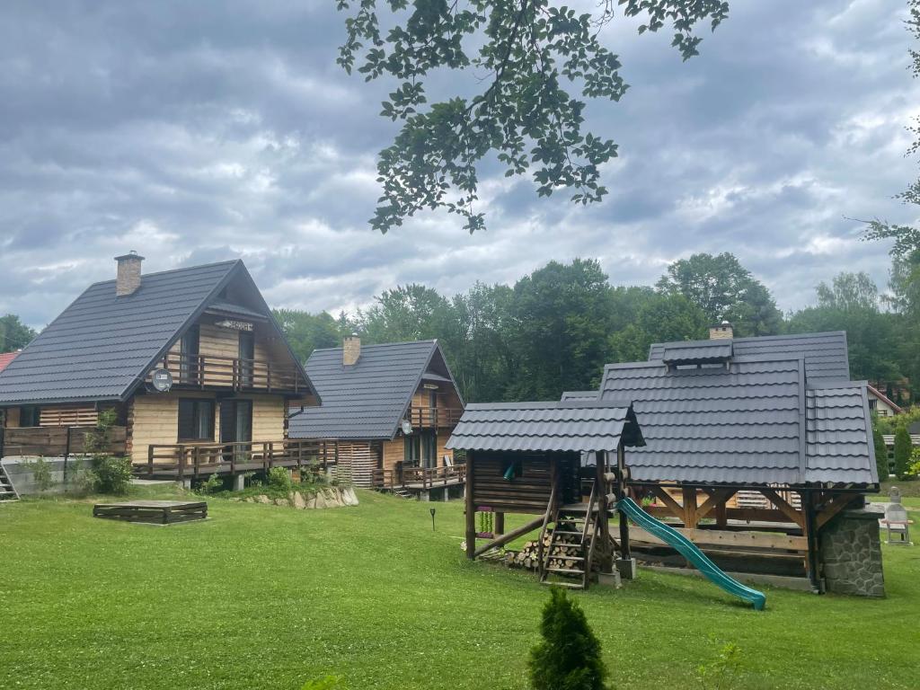a group of log homes with a playground at Gawra Werlas in Werlas