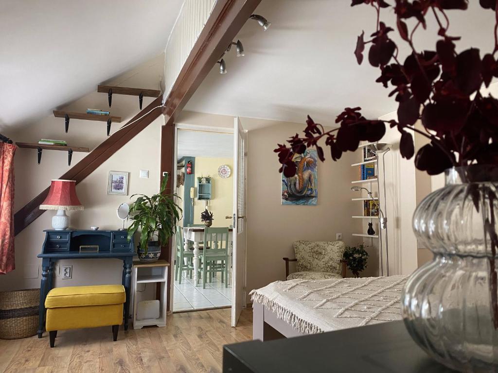 a room with a bed and a vase with a plant at Macskakő Apartman in Szentendre