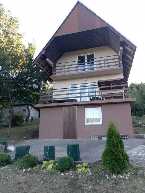 a house with two green chairs in front of it at Vila Tea Borsko Jezero in Bor
