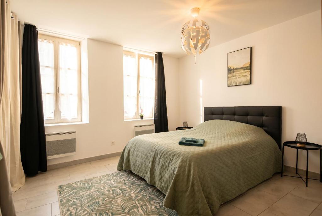 a bedroom with a bed and a chandelier at Quiet and bright studio in Gorze in Gorze