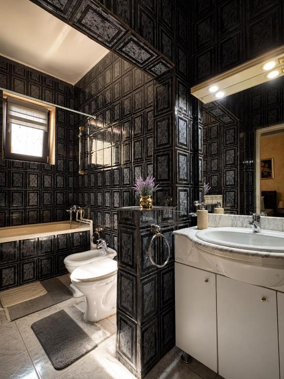 a bathroom with a toilet and a tub and a sink at Hotel Casa Italia in Calafat