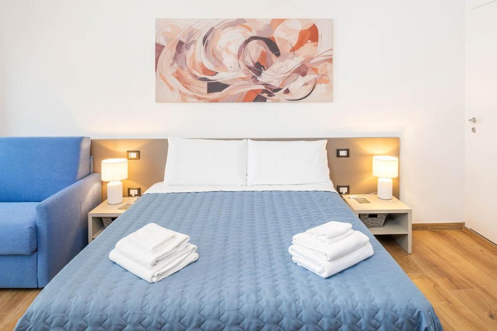 a bedroom with a blue bed and a blue couch at L'angolo del Forte in Rivoli Veronese