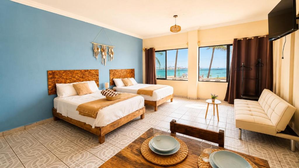 a bedroom with two beds and a couch and a table at Suites Puerto 201 in Veracruz