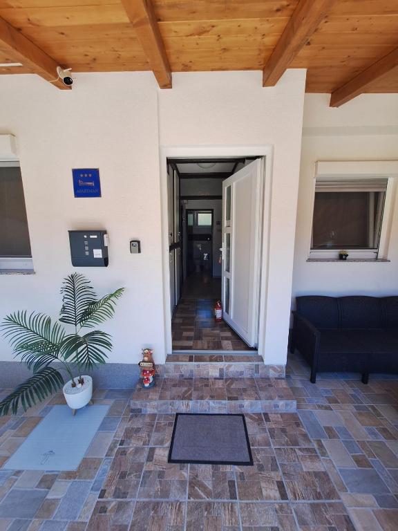 a hallway of a building with a door and a plant at Apartment Lela - self check-in and check-out in Otočac