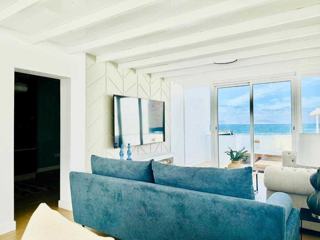 a blue couch in a living room with a view of the ocean at Canaryislandshost I Marino in Famara