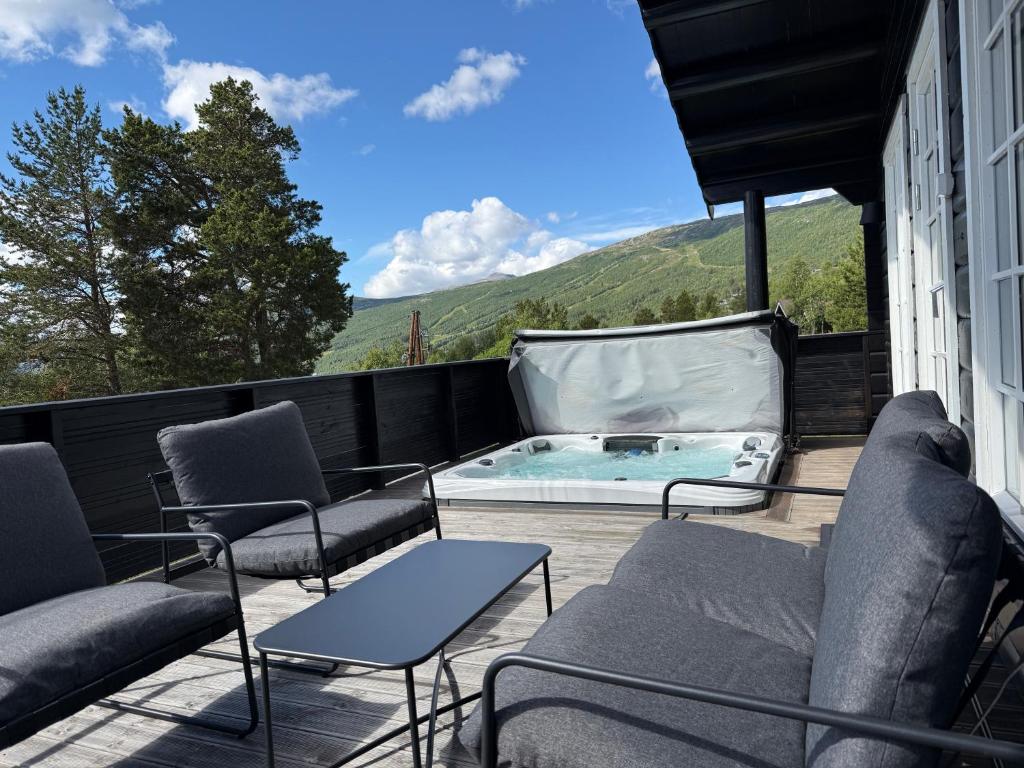 a patio with chairs and a swimming pool on a balcony at Fjellhytte med jacuzzi, badstue mulighet in Bjorli