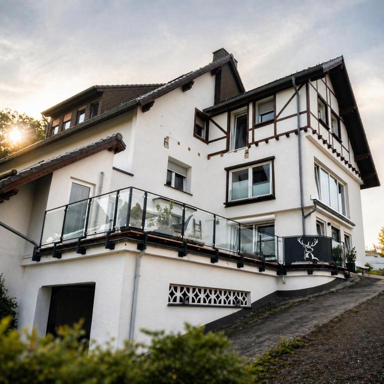 a white house with a balcony at Ferienwohnung Eifelglück in Pelm
