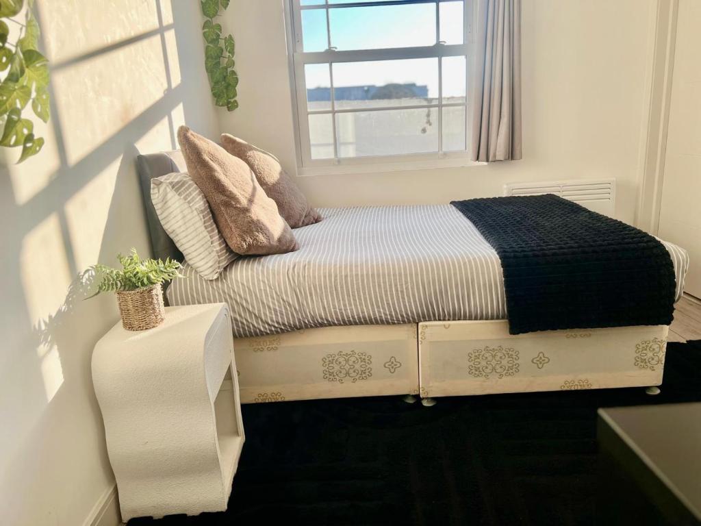 a small bedroom with a bed with a window at The Grove Sutton in Sutton