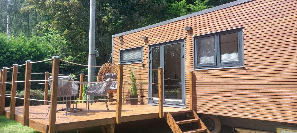 a cabin with a deck with a table and chairs at Tiny house U Lasiček in Perštejn