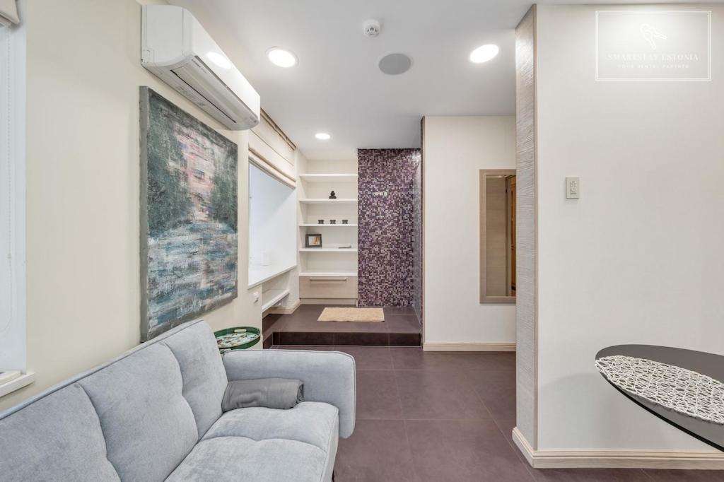 a living room with a couch and a table at Boutique Flat - Spa Shower - Sound System in Tallinn