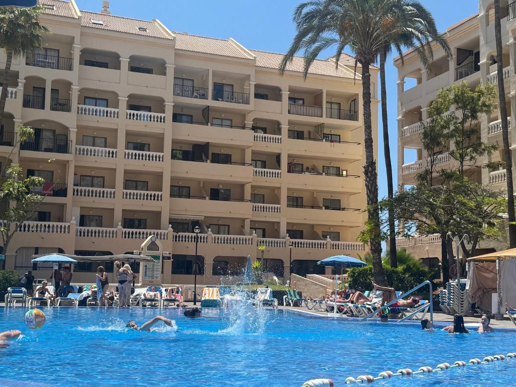 a swimming pool in front of a hotel at Castle Harbour 209 in Los Cristianos
