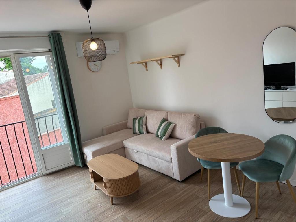 a living room with a couch and a table at Studio 7 in Fos-sur-Mer