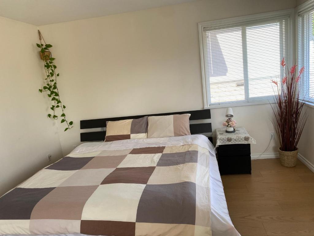 a bedroom with a bed with a checkered blanket at Cozy Room With King-sized Bed in Richmond