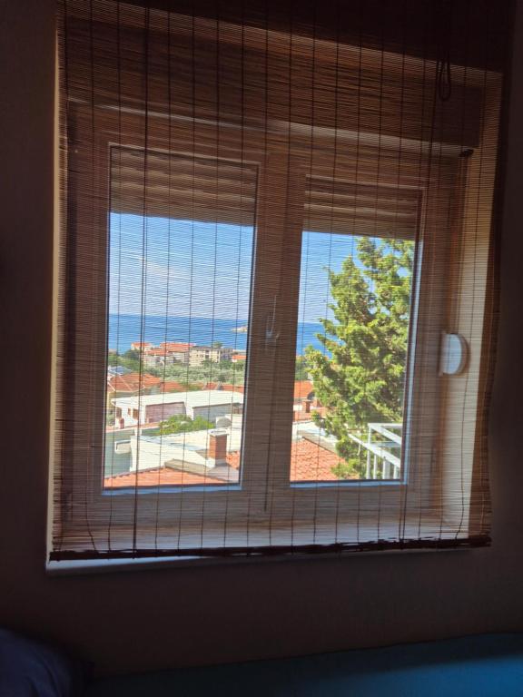 two windows in a room with a view of the ocean at Apartmani Bozenov in Petrovac na Moru