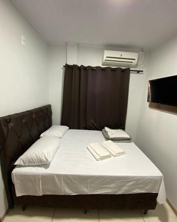 a bed with two books on it in a room at Hotel Villa Real in Pôrto Britânia