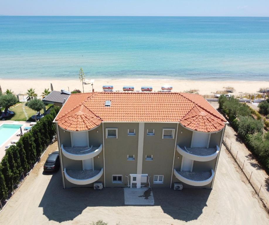 a house on the beach with the ocean in the background at Villa Naval in Nea Peramos