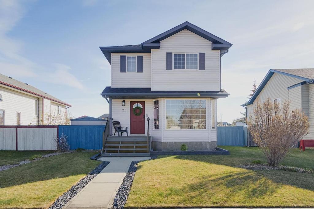 a white house with a red door at Lake Life Landing in Sylvan Lake